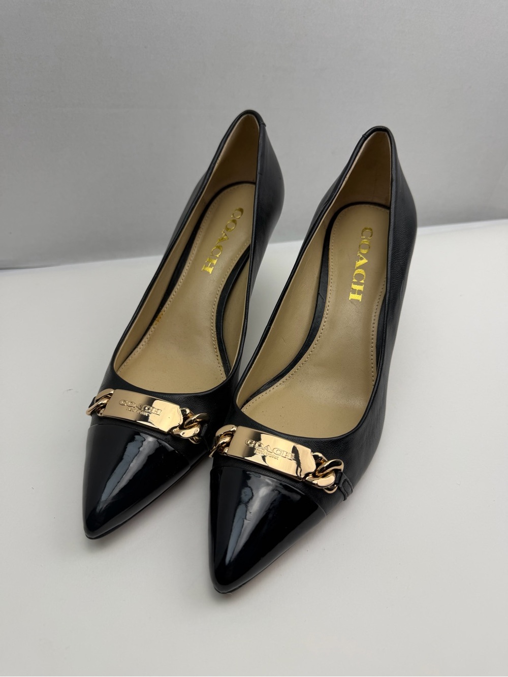 Coach Black Pointed Toe Pumps with Gold Chain Plaque